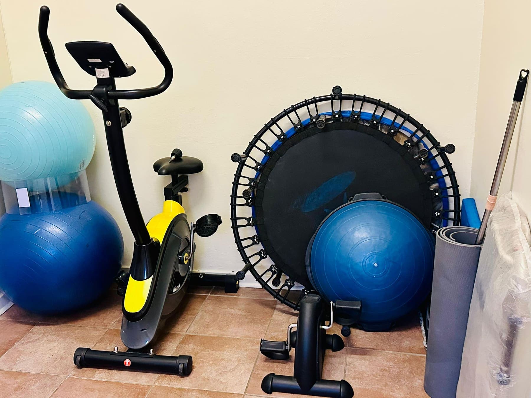 The rehabilitation corner at the African Mall clinic with an exercise bike, gym balls, a rebounder and rolled mats.