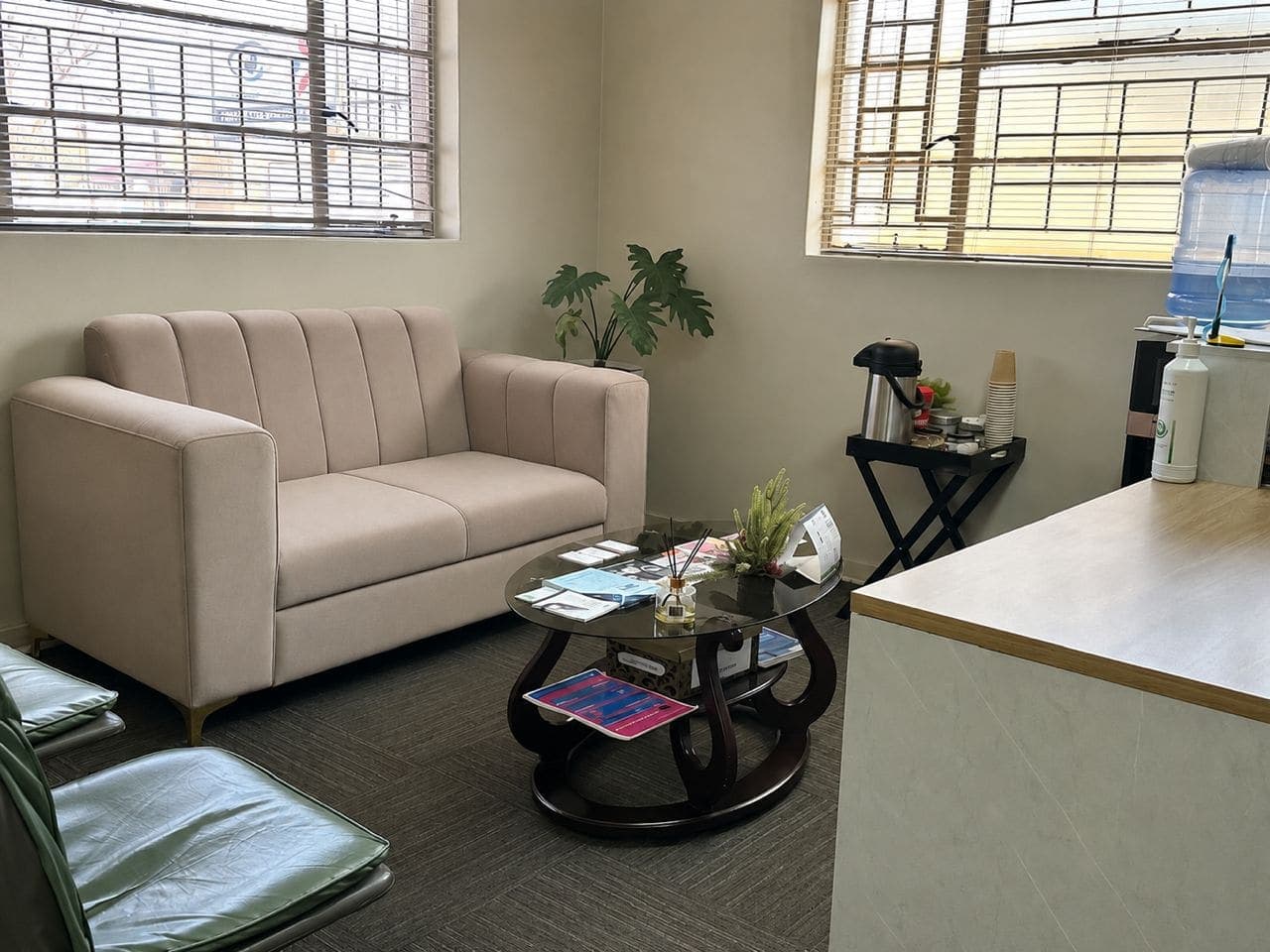 The waiting lounge at the African Mall clinic, with a sofa, a coffee table of reading material and a water cooler.