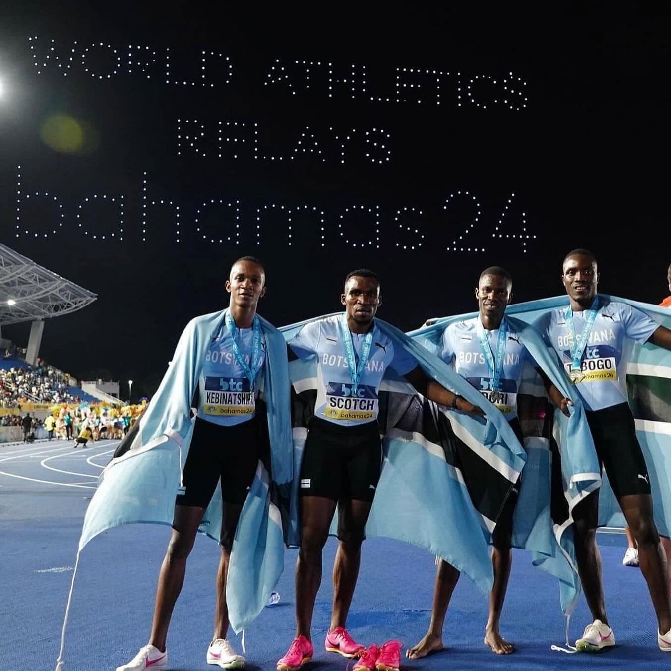 Botswana athletes on the track wrapped in national flags after competing at the World Athletics Relays.